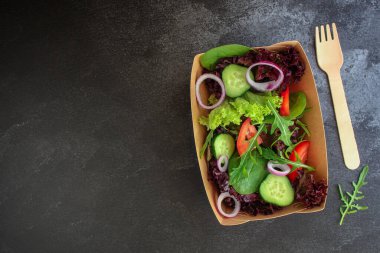 Marul, roka, domates, salatalık ve soğanlı taze salata.