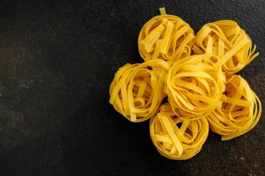 Siyah arkaplanda pişmemiş makarna 