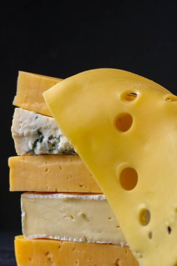 Koyu arkaplanda farklı peynir türleri, yakın plan görünümü