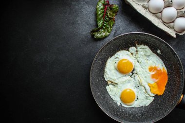 Tahta bir masada kızarmış yumurtalarla taze kahvaltı manzarası.