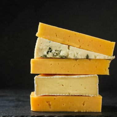 Koyu arkaplanda farklı peynir türleri, yakın plan görünümü