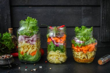 Kavanozda sağlıklı salata (sebzeli makarna salatası) menü kavramı. Yemek geçmişi. Üst Manzara. Boşluğu kopyala