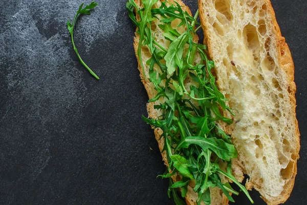 濃い色の背景にアルグラとチーズと緑のエンドウ豆のサンドイッチ トップビュー — ストック写真