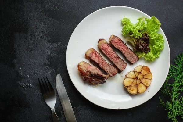 烤牛肉牛排 底盘上有酱汁和调味品 黑色背景 — 图库照片