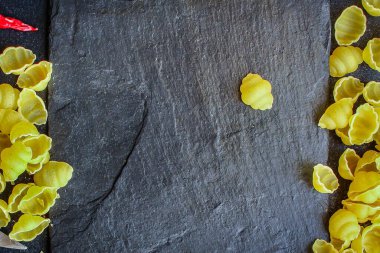 Koyu yüzeyde pişmemiş makarna üzerine üst görünüm