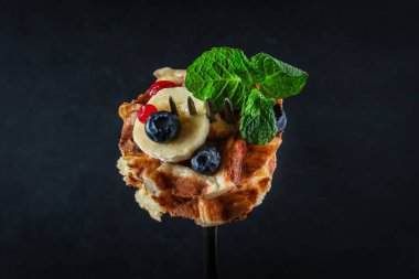 Koyu arkaplanda böğürtlen ve nane yapraklı Belçika waffleları