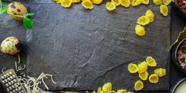 Koyu yüzeyde pişmemiş makarna üzerine üst görünüm