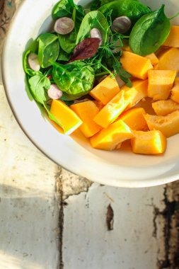 Sebzeli taze salata ve beyaz tabakta otlar.