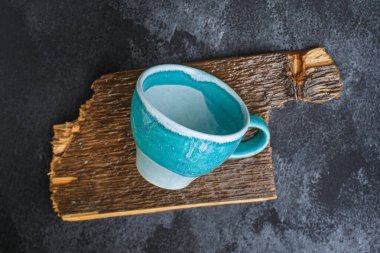 Siyah arka planda kesme tahtası olan mavi ve beyaz bardak, üst görünüm