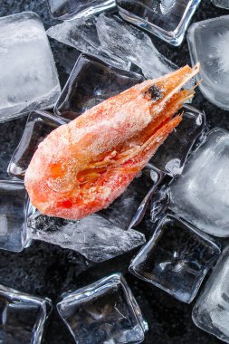 Karanlık yüzeyde buzlu karides.