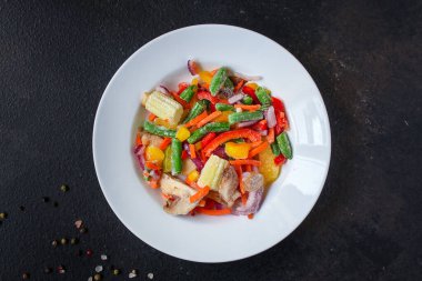 Tabaktaki donmuş sebzeleri kapat.