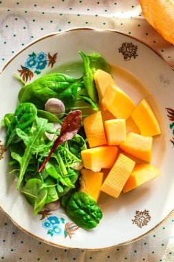 Sebzeli taze salata ve beyaz tabakta otlar.