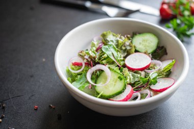 Taze sebzeli salata ve siyah arkaplanda roka. 