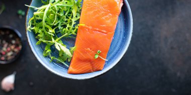 Limonlu somon filetosu ve tabakta bitkiler, yakın plan görüntü.