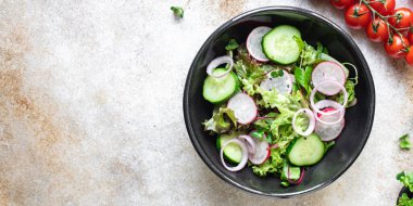 Taze sebzeli salata ve siyah arkaplanda roka. 