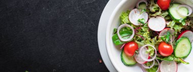 Taze sebzeli salata ve siyah arkaplanda roka. 