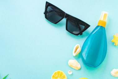 Yaz tatili plaj havası tropikal yaprak seyahat aksesuarları okyanus denizi, güneş kremi şişesi güneş gözlüğü, deniz kabuğu, limon manzarası.