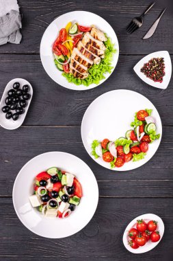 Menü sayfası salata aperatif sebzeler, Yunan salatası, ızgara tavuk salatası, masaya organik yemek. Fotokopi uzayı, yiyecek arka planı sade keto veya paleo diyeti vejetaryen veya vejetaryen.