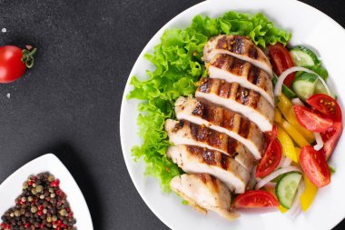 Salata ızgara tavuk göğsü domates, salatalık, soğan karışımı organik et tabağı masada sağlıklı yemek atıştırmalığı fotokopi alanı arka plan kırsal. üst görünüm keto veya paleo diyeti