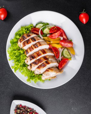 Salata ızgara tavuk göğsü domates, salatalık, soğan karışımı organik et tabağı masada sağlıklı yemek atıştırmalığı fotokopi alanı arka plan kırsal. üst görünüm keto veya paleo diyeti