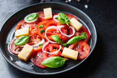 Domates salatası ve vejetaryen sebzeli fesleğen. Sağlıklı beslenme, atıştırmalık, fotokopi alanı arka plan kırsalı. Üst manzara vejetaryen yemekleri
