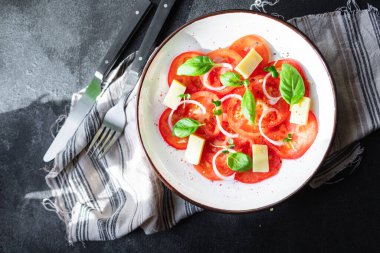Domates salatası ve vejetaryen sebzeli fesleğen. Sağlıklı beslenme, atıştırmalık, fotokopi alanı arka plan kırsalı. Üst manzara vejetaryen yemekleri
