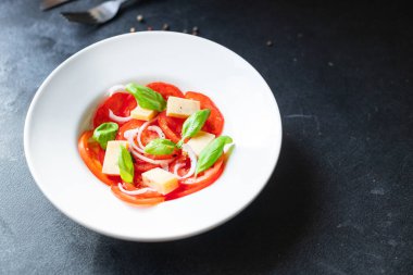 Domates salatası ve vejetaryen sebzeli fesleğen. Sağlıklı beslenme, atıştırmalık, fotokopi alanı arka plan kırsalı. Üst manzara vejetaryen yemekleri