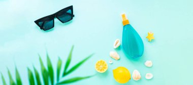 Yaz tatili plaj havası tropikal yaprak seyahat aksesuarları okyanus denizi, güneş kremi şişesi güneş gözlüğü, deniz kabuğu, limon manzarası.