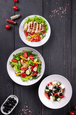 Salata menüsü. Salata, meze, sebze, Yunan salatası, ızgara tavuk yemeği masada. Sağlıklı beslenme. 