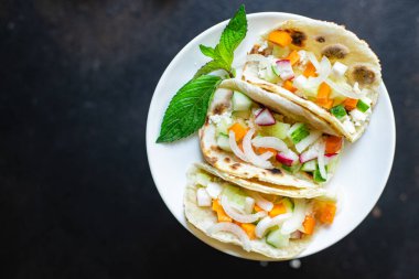 Takolar doldurulmuş sebzeler doner kebap düz ekmekler sebzeli taco masaya sağlıklı yemek atıştırmalıkları fotokopi arka plan kırsal. Top view keto ya da paleo diyet vejetaryen ya da vejetaryen yemekleri