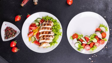 farklı salatalar sebzeler, ızgara tavuk göğsü, zeytin, feta, domates, soğan, salatalık masada diğer sağlıklı yiyecekler.