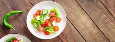 Salata sebzesi, salatalık, domates, soğan, marul yemeği organik ürünler, atıştırmalık uzay yiyecek arka planının kırsal kopyası. Top view keto ya da paleo diyet vejetaryen ya da vejetaryen yemekleri 