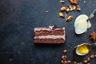 Bir parça kek çikolatalı fındık, kahve şurubu aromalı baharatlar, bal, ganache tatlısı tatlı bayram yemeği atıştırmalığı fotokopi uzay yemeği arka plan kırsal