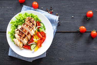 Salata ızgara tavuk göğsü domates, salatalık, soğan, biberli açık hava atıştırmalığı masa başı yemek arka plan kırsalında. üst görünüm keto veya paleo diyeti 