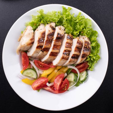 Salata ızgara tavuk göğsü domates, salatalık, soğan, biberli açık hava atıştırmalığı masa başı yemek arka plan kırsalında. üst görünüm keto veya paleo diyeti 