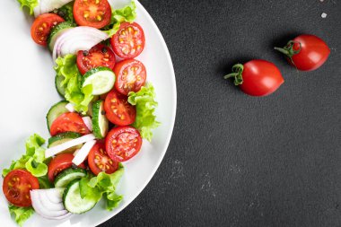 Salata taze sebze, marul, domates, salatalık, soğan, biberli açık hava atıştırmalığı, masa başı yemek arka planının sade kopyası. Top view keto ya da paleo diyet vejetaryen ya da vejetaryen yemekleri