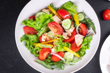 Salata taze sebze, marul, domates, salatalık, soğan, biberli açık hava atıştırmalığı, masa başı yemek arka planının sade kopyası. Top view keto ya da paleo diyet vejetaryen ya da vejetaryen yemekleri