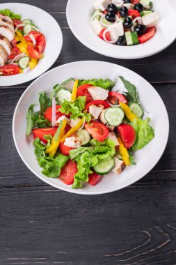 Salata taze sebze, marul, domates, salatalık, soğan, biberli açık hava atıştırmalığı, masa başı yemek arka planının sade kopyası. Top view keto ya da paleo diyet vejetaryen ya da vejetaryen yemekleri