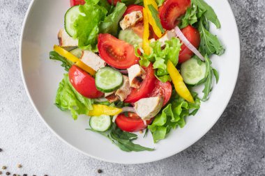 Salata taze sebze, marul, domates, salatalık, soğan, biberli açık hava atıştırmalığı, masa başı yemek arka planının sade kopyası. Top view keto ya da paleo diyet vejetaryen ya da vejetaryen yemekleri