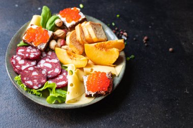 Atıştırmalık et, peynir, sosis, kırmızı havyar, meyve, fındık ezmesi masada. üst görünüm keto veya paleo diyeti