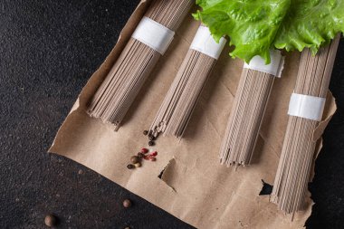 Soba karabuğday eriştesi, arka plandaki fotokopi masasında porsiyon yemek aperatifi pişirmeye hazır. Top view keto ya da paleo diyet vejetaryen ya da vejetaryen yemekleri