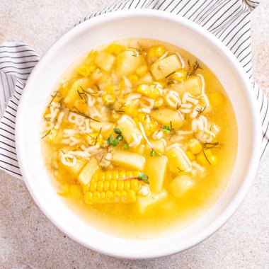 Çorba sebzeleri mısır, patates, makarna alfabesi, et suyu et suyu masadaki taze porsiyon yemek atıştırmalıkları arka plandaki uzay yiyecekleri kırsalında. Top view keto ya da paleo diyet vejetaryen ya da vejetaryen yemekleri