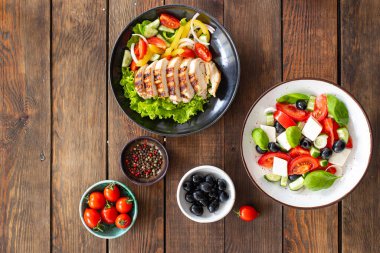 Salataların menüsü farklı sebzeler, et, şifalı bitkiler yemek için hazır taze porsiyon fotokopi makinesi arka plan kırsalında. üst görünüm keto veya paleo diyeti