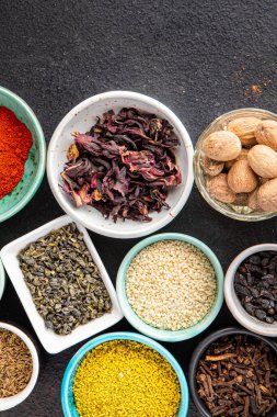 Yemek pişirmek için baharat ve otlar. Sumac, biber, biberiye, khmelisuneli, karanfil ve daha fazla taze porsiyon masa başı yiyecek arka planında yemek için hazır. en üstteki görünüm