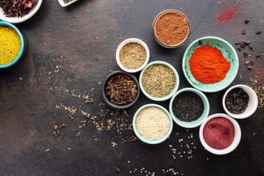 Yemek pişirmek için baharat ve otlar. Sumac, biber, biberiye, khmelisuneli, karanfil ve daha fazla taze porsiyon masa başı yiyecek arka planında yemek için hazır. en üstteki görünüm
