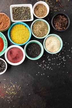 Yemek pişirmek için baharat ve otlar. Sumac, biber, biberiye, khmelisuneli, karanfil ve daha fazla taze porsiyon masa başı yiyecek arka planında yemek için hazır. en üstteki görünüm