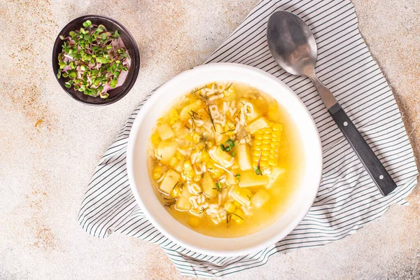 Mısır çorbası, vejetaryen sebze patatesleri, makarna alfabesi, sebze çorbası. Masada taze porsiyon atıştırmalığı yok. Arka planda fotokopi uzayı vejetaryen yemeği. 