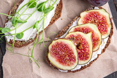 İncirli sandviç, krem peynirli sağlıklı kahvaltı taze porsiyon yemek için hazır yemek fotokopisi arka plan kırsalında. Top view keto ya da paleo diyet vejetaryen ya da vejetaryen yemekleri