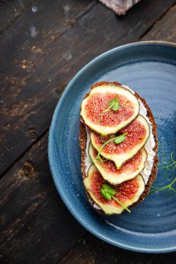 İncirli sandviç, krem peynirli sağlıklı kahvaltı taze porsiyon yemek için hazır yemek fotokopisi arka plan kırsalında. Top view keto ya da paleo diyet vejetaryen ya da vejetaryen yemekleri