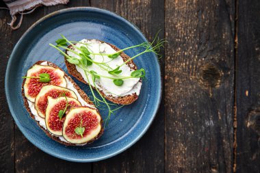 İncirli sandviç, krem peynirli sağlıklı kahvaltı taze porsiyon yemek için hazır yemek fotokopisi arka plan kırsalında. Top view keto ya da paleo diyet vejetaryen ya da vejetaryen yemekleri